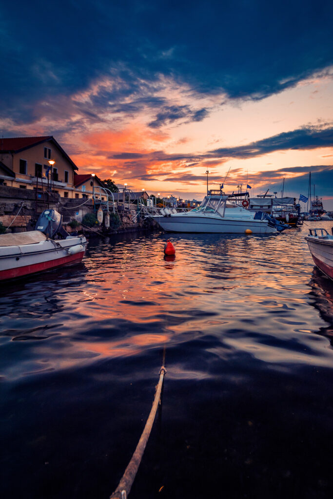 The harbour port of Alexandroupolis in Greece in the morning with many boats at the pier before the sunrise against a dramatic sky